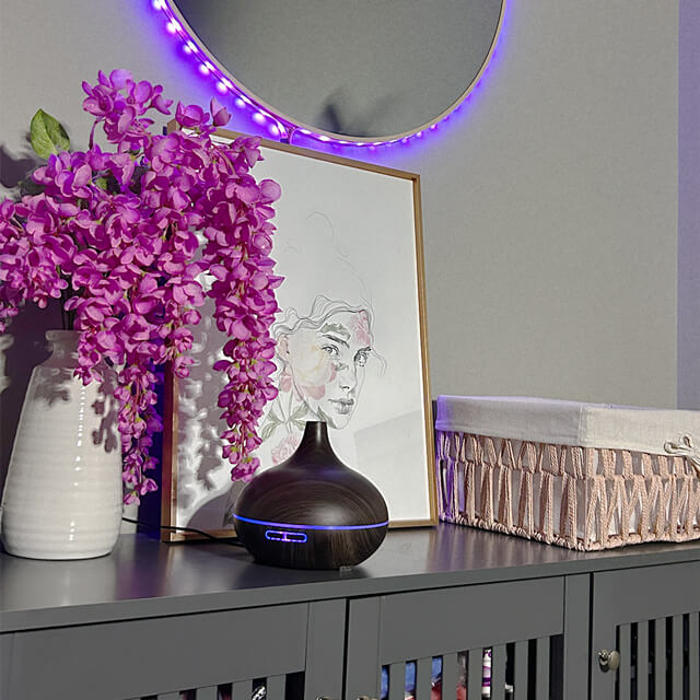 Elegant salon decor featuring vibrant purple flowers, an artistic portrait, and a stylish ultrasonic aroma diffuser.