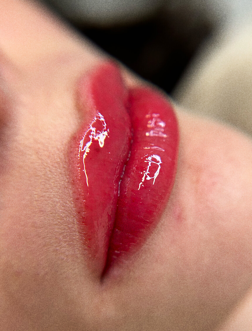 Close-up of luscious red lips with glossy finish, highlighting the detailed beauty work provided at a professional salon.